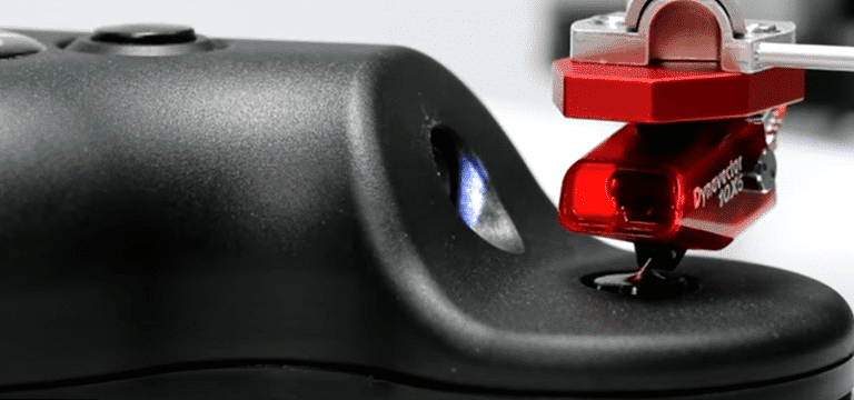 Ultrasonic stylus cleaner beneath a cartridge